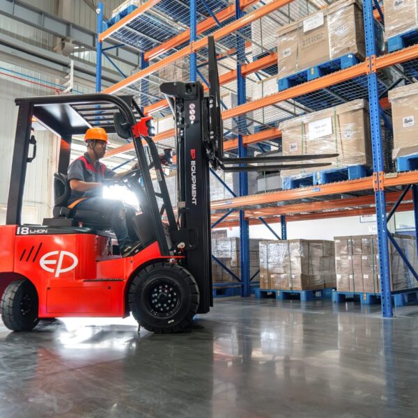 Tài xế vận hành xe nâng điện ngồi lái EP EFL 183 1.8 tấn trong kho, trải nghiệm sự êm ái nhờ bơm bánh răng độ ồn thấp và trục lái giảm xóc.